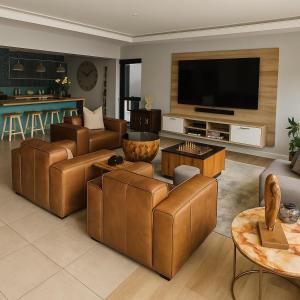 a living room with leather furniture and a flat screen tv at 1442 Marina by Double Portion in Jeffreys Bay