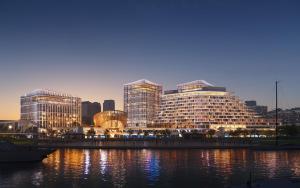 a rendering of a large building next to a river at Waldorf Astoria Shanghai Qiantan in Shanghai