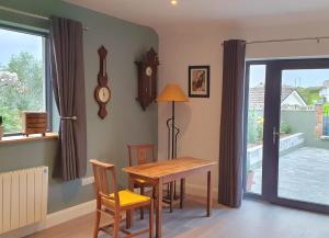 a dining room with a table and chairs and a clock at The Courtyard in Lahinch