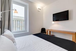 a bedroom with a bed with a tv and a window at Sora Luxury Inn in Rome