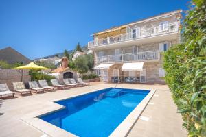 a swimming pool in front of a building at Apartmani Bezmalinović in Bol