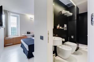 a bathroom with a bed a sink and a toilet at Sora Luxury Inn in Rome