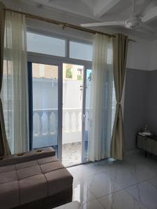 a bedroom with a bed and a sliding glass door at AC one bedroom apartment , 5 min walk from bofa road, baobab resort ,Canna Lily in Kilifi