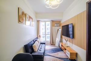a living room with a couch and a tv at Pioneer Woodlands Tower 5 Unit 33-Q in Manila