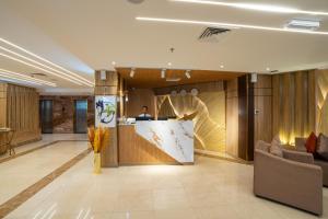 a man standing at a counter in a lobby at Plaza Athenee Hotel in Kuwait