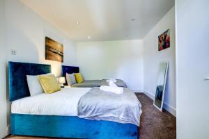 a bedroom with a large bed with a blue headboard at 1BR Wapping Flat, Free Parking, Sleeps 4 in London