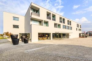 a white building with black pots in front of it at Villa C Boutique Hotel in Vila do Conde