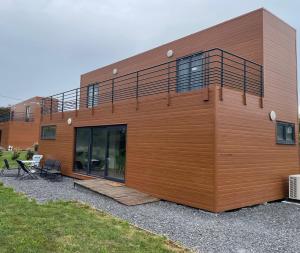 drewniany budynek z balkonem na boku w obiekcie Le Normandy - Sauna - A moins de 2 km de la plage w mieście Sainte-Honorine-des-Pertes