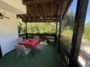 un patio con tavolo rosso e sedie sul balcone. di Къща за гости Сияйна Зора a Plachkovtsi Altre 46 foto