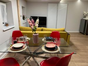 a living room with a glass table and red chairs at Bytom Cabernet in Bytom