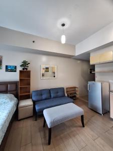 ein Wohnzimmer mit einer blauen Couch und einer Küche in der Unterkunft Eastwood Legrand3 Studio Type condo in Manila