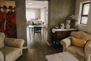 a living room with two couches and a dining room at Stone Olive Guesthouse in Jeffreys Bay