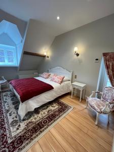 a bedroom with a large bed and a chair at Le Clos Haton - HAUTVILLERS in Hautvillers