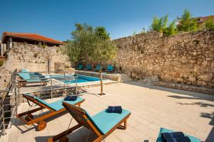 un patio con sillas y una piscina en California Apartments, en Dubrovnik