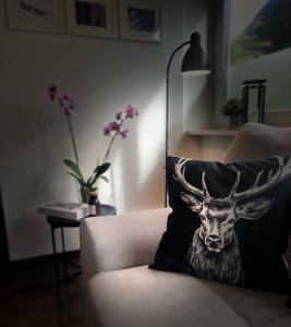 a cushion with a picture of a deer on a couch at Ferienwohnung Paradies Hella in Kippenheim