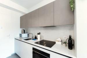 una cocina con fregadero y microondas en Studio Besso 31 by Quokka 360 - flat 10 minutes from the railway station, en Lugano