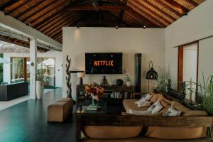 a living room with a couch and a tv at CALA NINETA Private Villa in Dalung