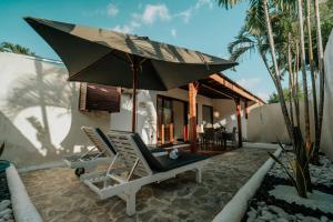 a couple of chairs and an umbrella on a patio at CALA NINETA Private Villa in Dalung