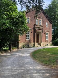 une maison en briques avec une allée en face de celle-ci dans l'établissement Das Ministerhaus - historisches Anwesen für Gruppen und Seminare, à Bergkamen