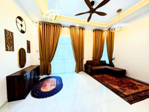 a living room with a couch and a ceiling fan at Mimpi Hillview Homestay in Kuala Terengganu