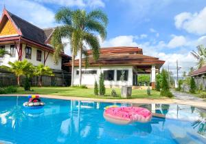 una casa con una piscina con dos inflables en Per La Villa Khao Lak, en Khao Lak