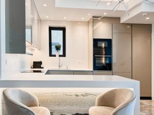 a kitchen with two chairs and a large white counter at FOS Luxury Apartment with View of Nafplio in Nafplio +13 photos