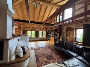 un soggiorno con divano in pelle nera e soffitti in legno di Naturoase, Nähe Arlberg und Montafon, Perfekter Startpunkt zum Skifahren ! a Grünkraut