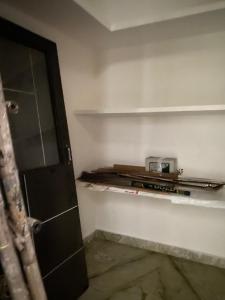 a kitchen with a shelf with a toaster on it at Swamiji niwas in Morādābād