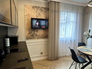 a living room with a television on a wall at Willa Piastowska in Polanica-Zdrój