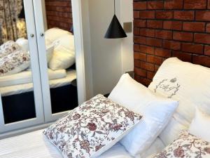 a bedroom with a mirror and a bed with pillows at Willa Piastowska in Polanica-Zdrój