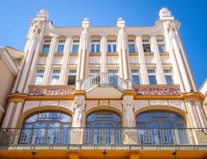 a building with a balcony on the side of it at Palatinus Grand Hotel in Pécs