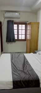 a bedroom with a white bed with a window at Nest-In Homes in Hyderabad