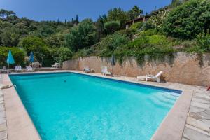 a large swimming pool with chairs and a wall at Villa Bellevue Avec Vue Mer in Saint-Peïre-sur-Mer