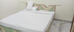 a small bed with white sheets and pillows on it at Nest-In Homes in Hyderabad