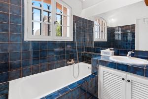 a blue tiled bathroom with a tub and a sink at Villa Bellevue Avec Vue Mer in Saint-Peïre-sur-Mer +19 photos