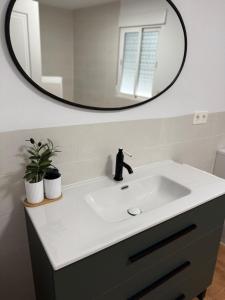 a bathroom with a white sink and a mirror at Casa rural Aires de Magina Jaén in Carchel