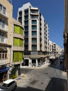 an empty street in a city with tall buildings at Gzira Getaway in Il-Gżira