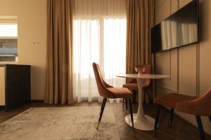 a room with a table and chairs and a window at Nest Inn Charm Apartment in Baia Mare