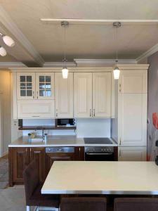 a kitchen with white cabinets and a counter top at Bregu diellii,nice wiew of Pr in Pristina