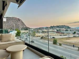a living room with a large window with a view of a highway at FOS Luxury Apartment with View of Nafplio in Nafplio
