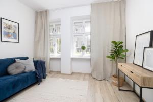 Una sala de estar con un sofá azul y una ventana. en Beautiful Apartment in Erdody Palace, en Otilia