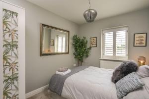 a bedroom with a bed with a mirror on the wall at Beautiful Home & Garden in Somerset Countryside in East Lydford