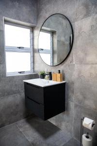 a bathroom with a sink and a mirror at Seaside Studio in Yzerfontein