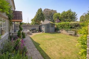 a garden with a bench and a shed at Beautiful Home & Garden in Somerset Countryside in East Lydford