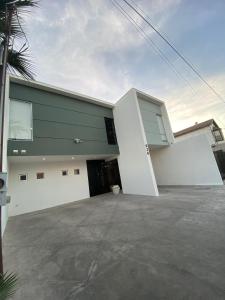 un edificio bianco e verde con parcheggio di Departamentos Raices - Jardines del Lago a Mexicali