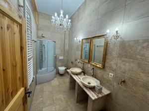 a bathroom with two sinks and a toilet and a chandelier at Zum Böhmen Ferienwohnung Hermann von Salza in Bad Langensalza
