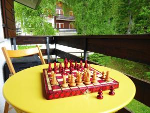 a chess set on a yellow table on a balcony at Chalet Giove in Belluno