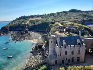 an aerial view of a castle on a hill next to the ocean at L'ormeau in Frehel