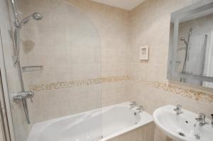 a bathroom with a bath tub and a sink at Seascape in Swanage
