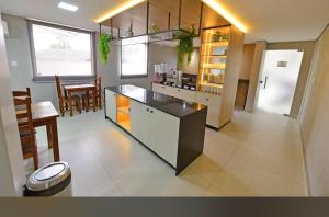 a kitchen with a counter and a dining room at Hotel Castanheira in Ipatinga